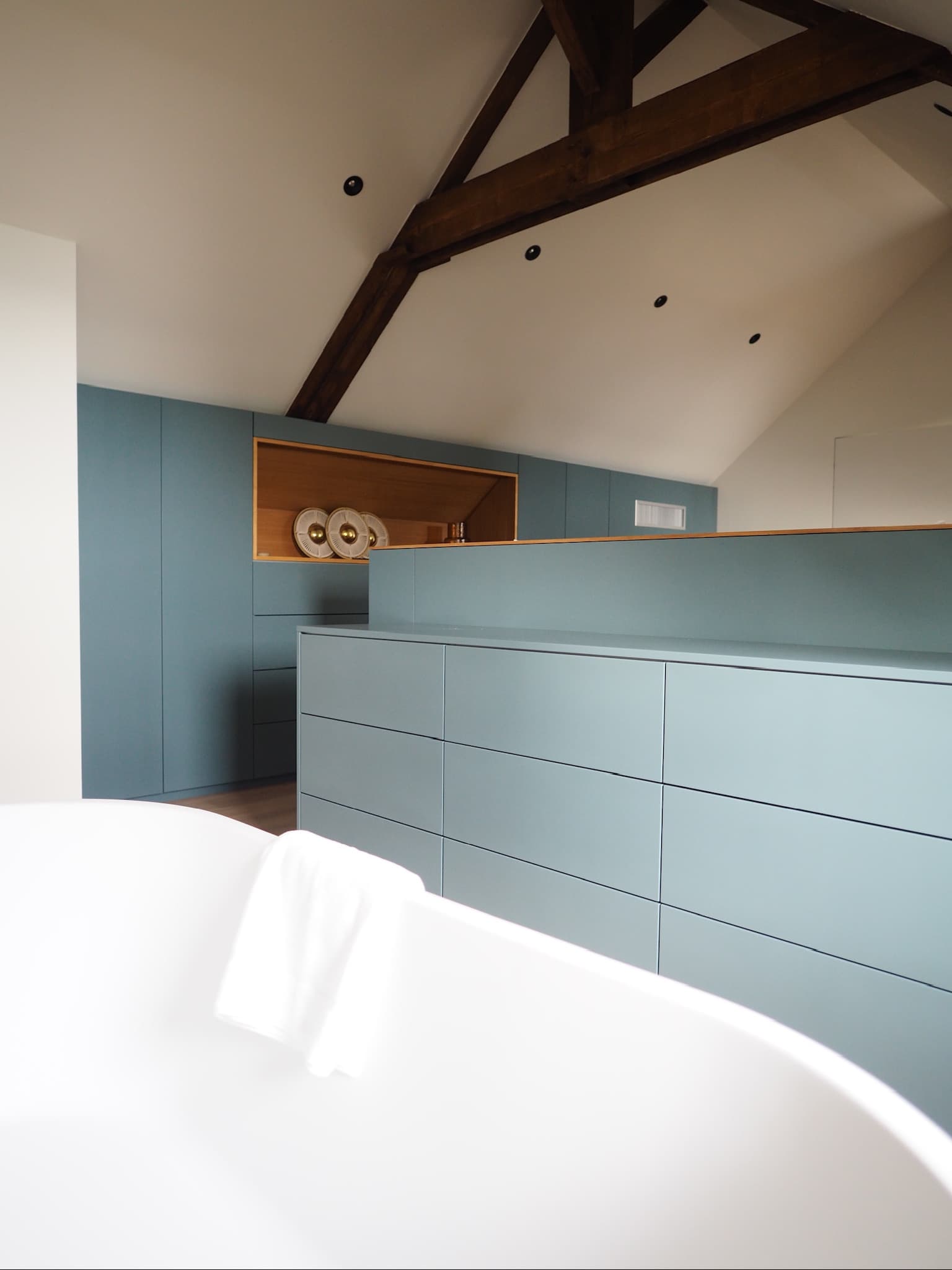 Chambre sous comble avec tête de lit ilot en chêne canelé et laque gris-bleu, poutres apparentes et niche décorative, projet Quiberon A4 Créations