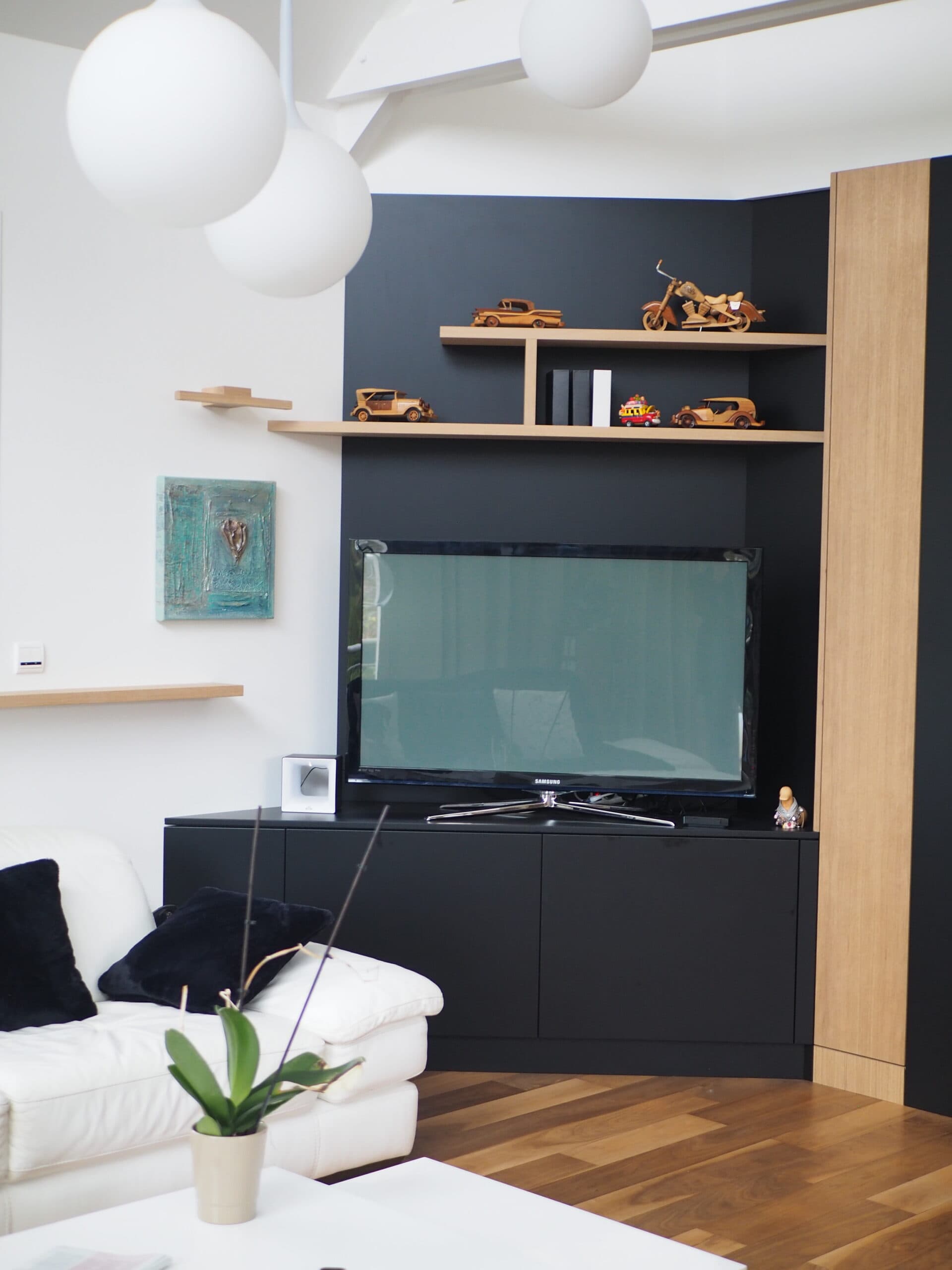 Meuble TV en MDF laque noir mat et placage chêne avec étagères, suspensions sphériques blanches, projet Ploemeur A4 Créations