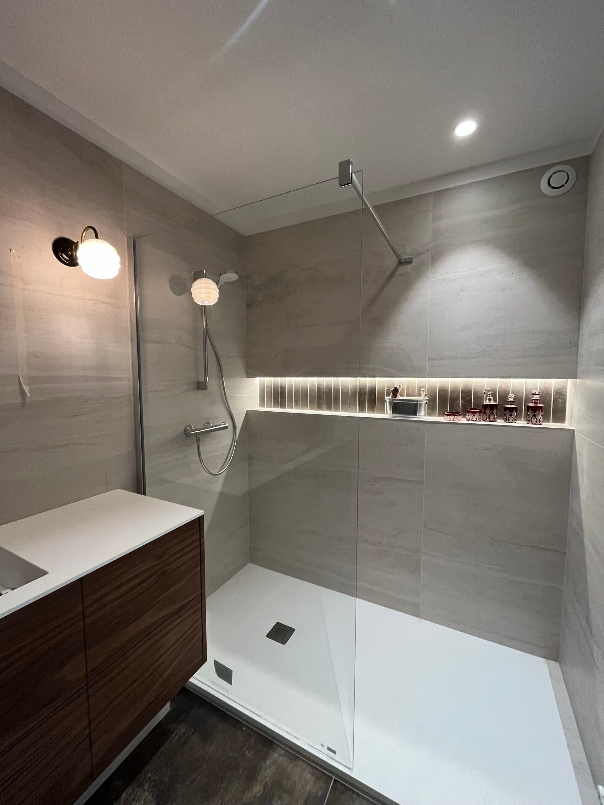 Salle de bain moderne avec douche à l'italienne, meuble vasque en noyer et carrelage gris, projet Larmor-Plage A4 Créations