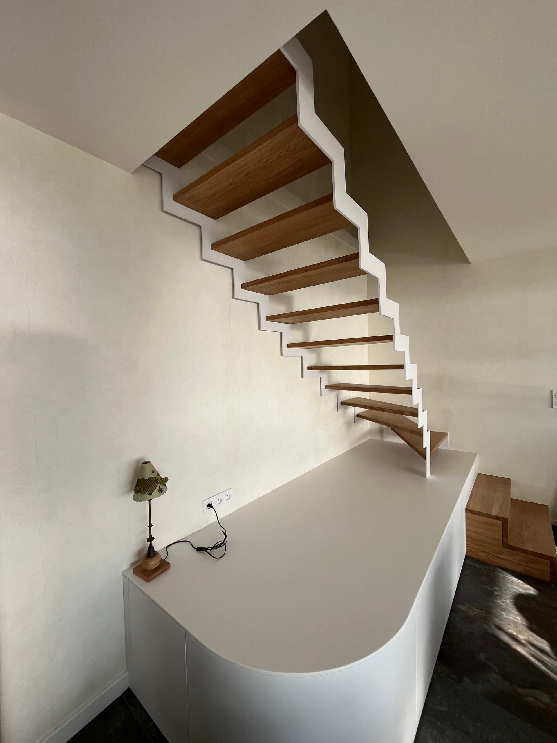 Escalier avec limon métallique, marches en chêne massif et meuble en laque et résine Krion, projet Larmor-Plage A4 Créations
